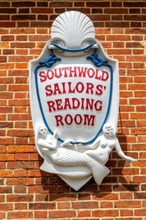 Sign with mermaids on Southwold Sailors Reading Room building, Southwold, Suffolk, England, UK