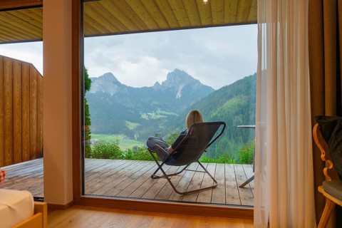 Cosy view from a window to the mountains, person sitting relaxed in an armchair, Dolomites, South