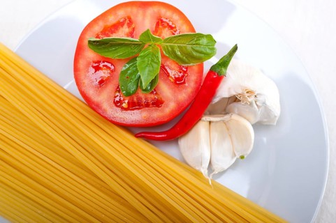 Italian spaghetti pasta tomato raw ingredients basil garlic and red chili pepper