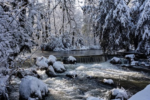 Waterfall at the Eisbach, winter with snow in the southern part of the English Garden, Munich,