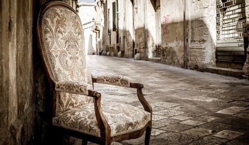 Lecce town, Italy. Vintage chair with old town street in background