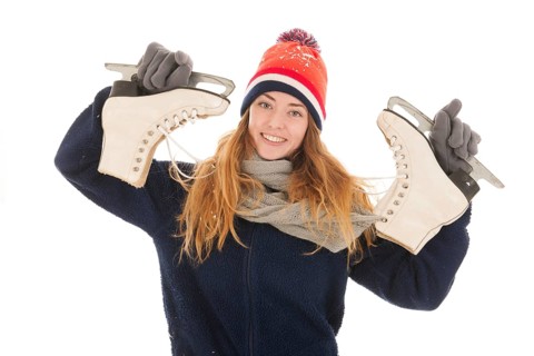 Attractive Dutch woman is ahving fun with ice skates isolated over white background