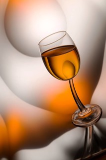 Glass of cognac in a distorted reflection