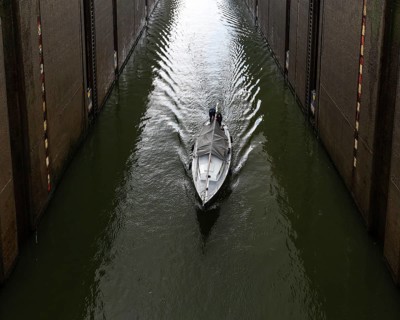 Maasbracht, Limburg, The Netherlands, 04 20 2022, Large sluice gate with a small vessel passing by,