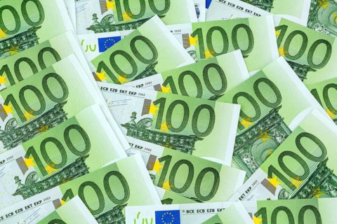Many one hundred euro banknotes lying next to each other. Symbolic photo for wealth and investment
