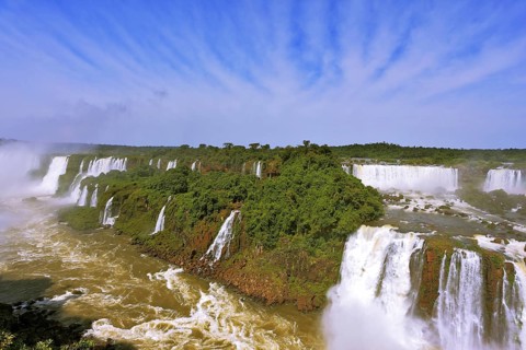 Roaring falls in South America - Iguazu. Foamy streams fall between the green jungle. The
