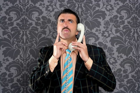 Businessman with scared expression talking by telephone with retro mustache