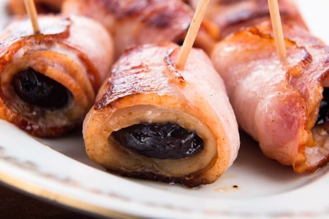 Baked prunes in bacon on a plate, lodz, poland