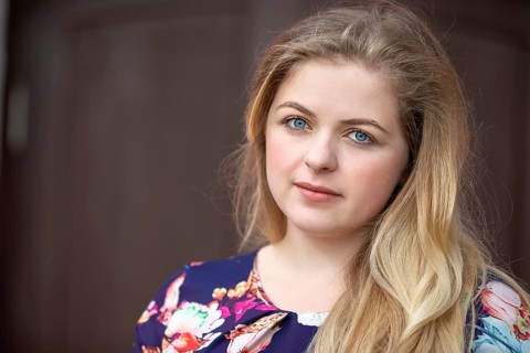 Portrait of a blonde girl with blue eyes. A girl with a European style face