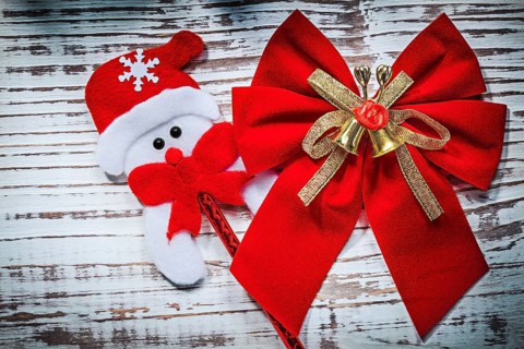 Santa Claus toy red bow on vintage wooden board celebrations concept
