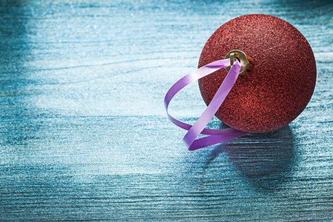 Red shining Christmas ball on wooden board holidays concept