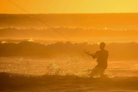 Single surfer at sunset on a calm ocean