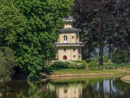 Historic turret flanked by trees, reflected in the neighbouring water, ulft, gelderland,