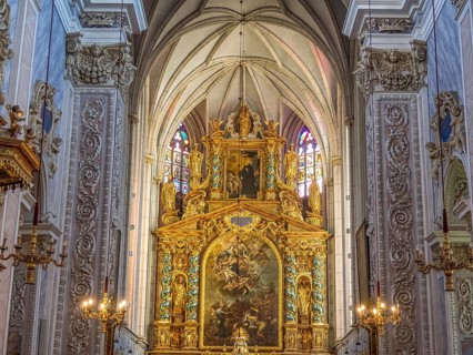 Gold-decorated altar in the Baroque church interior with ornate paintings and decorative details on