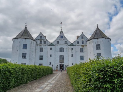 An impressive white castle with several turrets under a cloudy sky, glücksburg, schleswig-holstein,