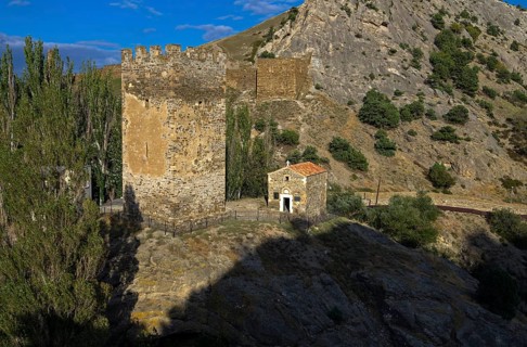 Medieval tower and old Christian temple near the ruins of the Genoese fortress in Sudak, Crimea