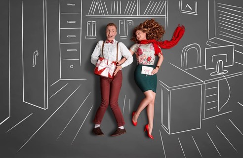 Happy valentines love story concept of an office romance. Young couple at work smiling at each