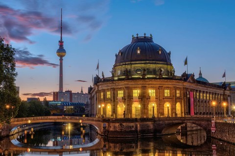 The Bode Museum in Berlin in front of sunrise with the famous television tower in the background