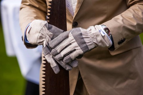 Man wearing gloves and holding saw