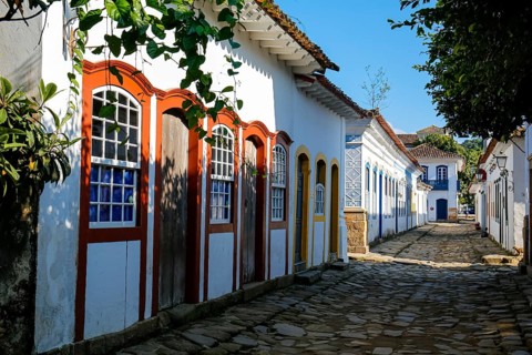 Typical cobblestone street with colorful colonial buildings in the late afternoon sun and shadows