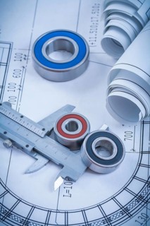 Rolls of construction drawings round rolling bearings and trammel caliper on blueprint industrial