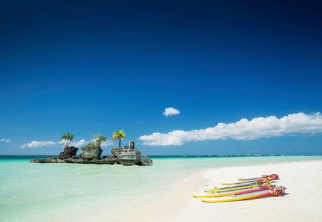Tropical beach christian shrine and tourist canoes on boracay island philippines