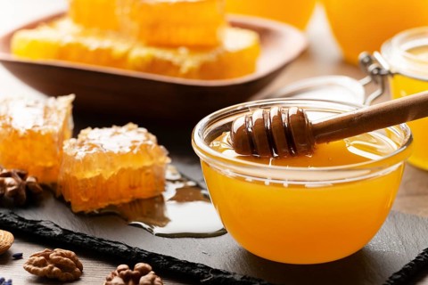 Honeycomb on slate tray with honey and nuts on kitchen table, food photography, food photography