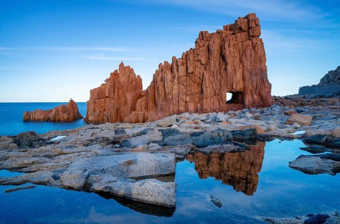 A view of the red rocks of Arbatax with reflections in tidal pools in the foreground