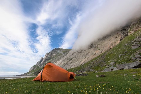 Tent at the foot of a rock face, Buneset, Moskenesöya, Lofoten, Nordland, Norway, July 2015, Europe