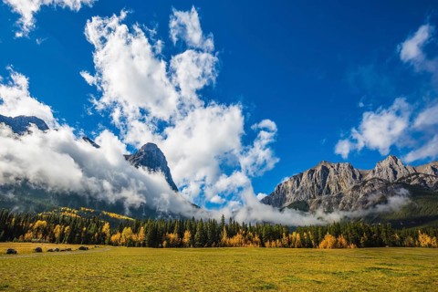 Concept of hiking. Auroral sunny day in Canmore. The famous Three Sisters mountains in the Canadian