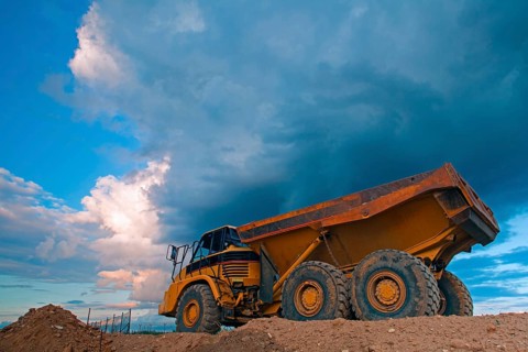 Yellow mining truck at work site before heavy storm