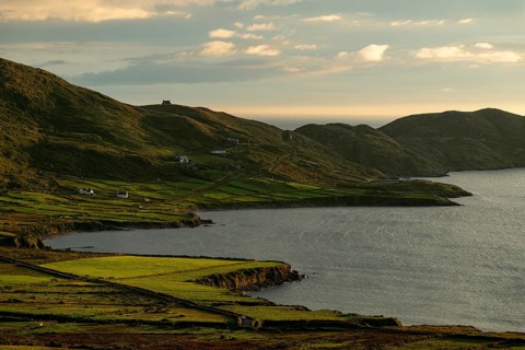 Coastal landscape on the Ring of Kerry near Waterville, with green fields and scattered houses in