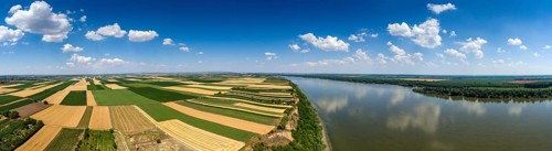 Aerial panorama of colorful fields on high bank of Danube river in Serbia
