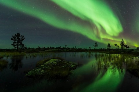 Northern Lights (Aurora borealis) reflected in a mountain lake, Gällivare, Norrbotten, Lapland,