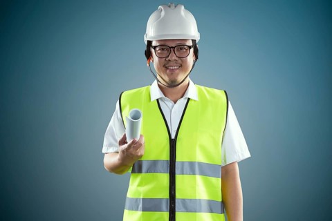 Porträt eines zuversichtlichen asiatischen jungen Ingenieur mit schützenden harten Hut und halten