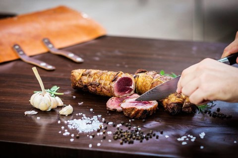 Serving carving roast pork meat roll meal in rustic style with seasonings
