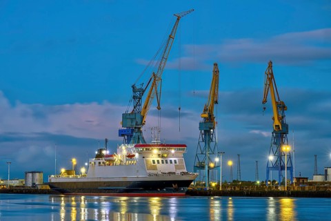 Three yellow and blue cranes at dusk in the harbour of Belfast, Northern Ireland