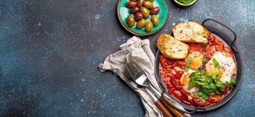 Middle Eastern and Maghrebi healthy dish Shakshouka made of eggs and tomato sauce served in pan