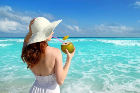 Beach hat profile girl drinking acoconut fresh cocktail in tropical Caribbean sea