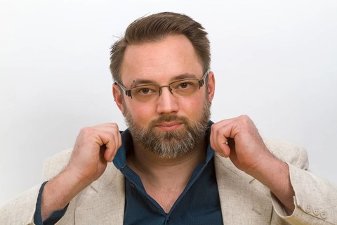 Man straightens his shirt collar - on a light background