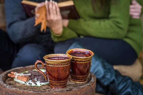 Two cups of coffee are on wooden barrel
