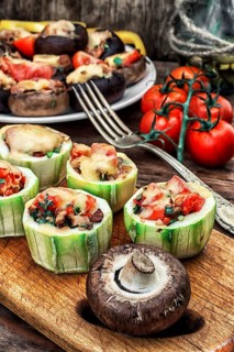 Easy appetiser of courgette stuffed with cheese, garlic and tomatoes.Photo tinted.Selective focus