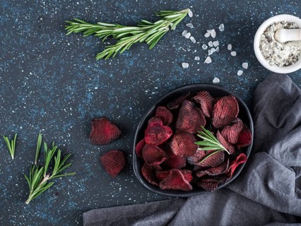 Baked beet slices with coarse sea salt scented rosemary. Vegan diet food idea and recipe. Healthy