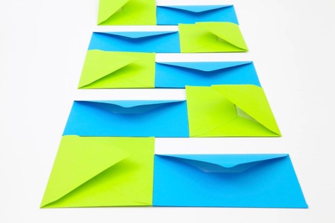 Composition with green and blue envelopes on the white table