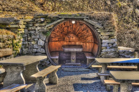 Rustic Restaurant with Tables and Benches Made in Stone and Wood in Circle Shape in a Sunny Day in