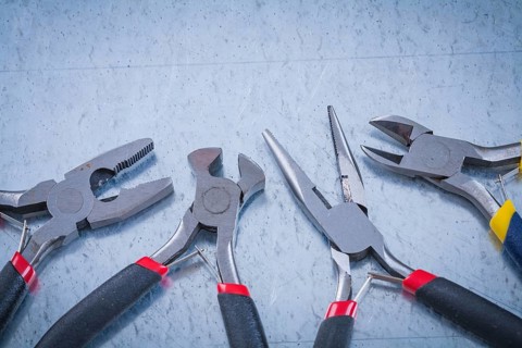 Composition of insulated metal nippers on scratched metallic background