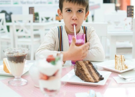 Child drink lemonade. Cake and a milkshake in confectionery