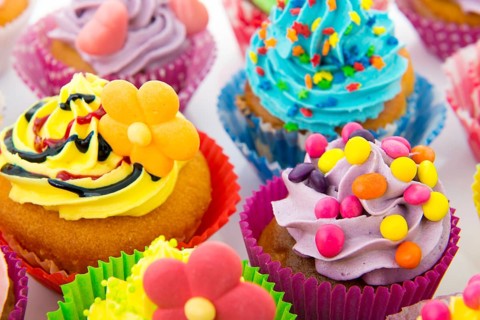 Many sweet birthday cupcakes with flowers and butter cream