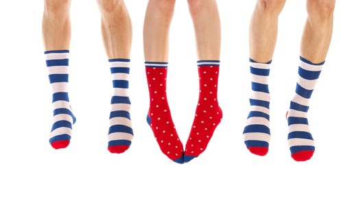 Feet in striped and dotted socks isolated over white background