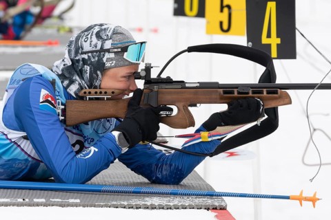 Sportswoman biathlete Arina Soldatova Kamchatka Krai rifle shooting prone position. Biathlete in